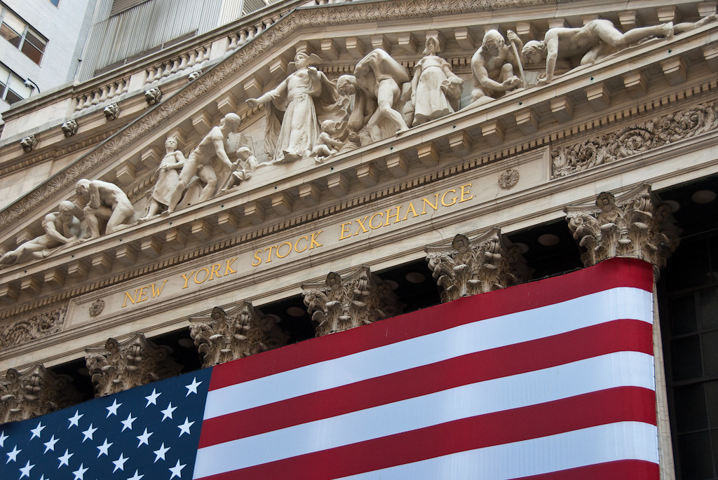 미국 뉴욕증권거래소(NYSE) 건물 정면에 새겨진 글자와 성조기가 보이는 이미지로, 분기 실적이 몰리는 어닝시즌에 시장이 주목하는 증시를 상징한다